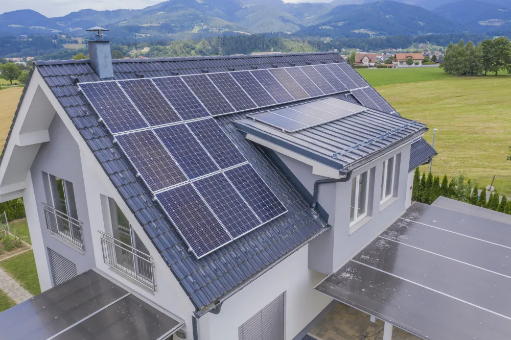 Maison dans la campagne avec panneaux solaires sur le toit.